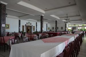 图克图克Toledo Inn的用餐室配有桌椅和红白桌布