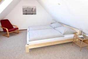 LenzenHaus Löcknitz - Ferienhaus in Lenzen (Elbe)的一间卧室配有一张床和一张红色椅子