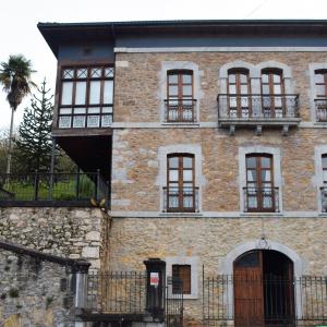 奥维多Palacete Peñanora的一座旧砖砌的建筑,有窗户和树
