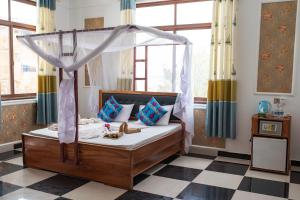肯杜瓦莫克海滩别墅旅馆的一间卧室设有一张天蓬床和一张可调节的地板。