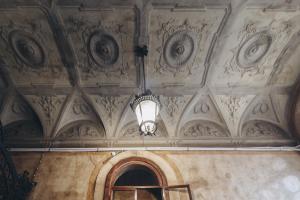 博洛尼亚Gregorini Bingham Art Luxury Suites的一间带吊灯的天花板客房