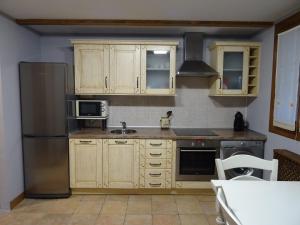 莱萨卡Apartamento Usuaia con jacuzzi的厨房配有木制橱柜和不锈钢冰箱。
