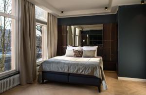 阿姆斯特丹Spinoza Suites的一间卧室设有一张床和一个大窗户