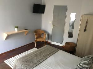 卡普费雷蓝旗酒店的一间卧室配有一张床、一把椅子和镜子