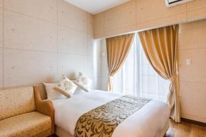 名户Condominium Hotel Likka in Nago的一间卧室设有一张大床和一个窗户。