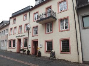 WaxweilerHotel Haus Irsfeld的街道上一座大型白色建筑,设有阳台