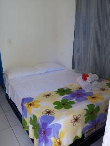 费尔南多 - 迪诺罗尼亚Blue House的一间卧室,床上放着鲜花