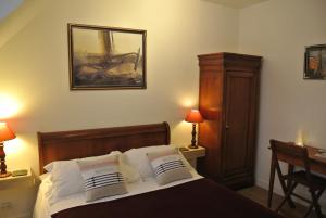 圣茹昂代盖雷特Au Logis De La Rance Bed and Breakfast的一间卧室配有一张带两个枕头的床