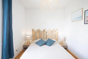 阿雅克修T2 - sanguinaires - Superbe vue mer - proche centre ville的一间卧室配有白色的床和2个蓝色枕头