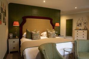 安布尔塞德罗塞庄园酒店的一间卧室配有一张大床和两把椅子