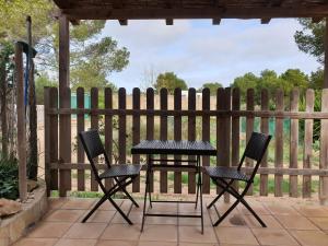 米乔尔海滩Tranquilidad y naturaleza a 800m Playa Migjorn的庭院设有围栏,配有桌椅