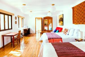 墨西哥城哈辛塔之家旅馆的一间卧室配有两张床、一张桌子和一张书桌
