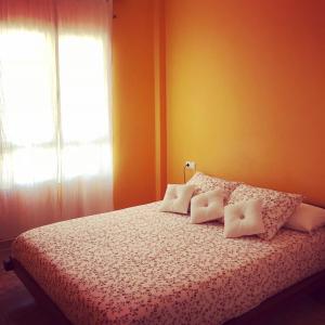 大塔拉哈尔Ático Sun&Beach的卧室配有带白色枕头的床和窗户。
