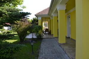 波罗斯洛Arany Tisza Vendégház的一座拥有黄色墙壁和走道的房子