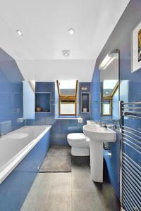 戈尔布里奇The Arches, Borthwick Mains Farm,的蓝色的浴室设有水槽、浴缸和卫生间。
