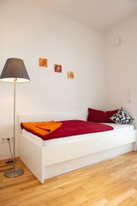 慕尼黑MyRoom - Top Munich Serviced Apartments的一张带红色床单和灯的白色床