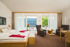 蒂蒂湖-新城BRUGGER' S Hotelpark Am Titisee的酒店客房,配有一张床、一张桌子和椅子