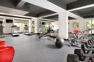 塞米亚克Ramada Encore by Wyndham Bali Seminyak的一间健身房,里面配有数台跑步机和椅子