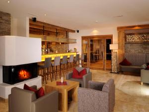 瑟弗浩斯加尼阿尔卑具维尔酒店的带壁炉的客厅和酒吧