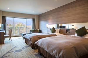 富士河口湖富士豪景酒店的酒店客房设有两张床和大窗户。