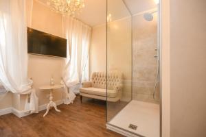 西尔米奥奈Luxury Suite Sirmione的带淋浴、长凳和桌子的浴室