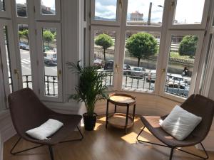 毕尔巴鄂Apartamento en el centro de Bilbao的带窗户的客房内配有两把椅子和一张桌子