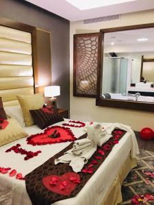 达曼Ramada by Wyndham Dammam Khaleej Road的一间卧室配有一张红色鲜花的大床
