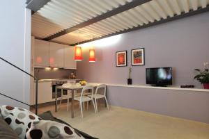 安德里亚Foresteria Pellegrino的厨房以及带桌子和电视的客厅。