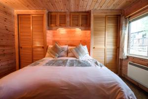 凯西克Fellside Lodge的木制客房内的一间卧室配有一张大床