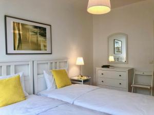 日内瓦Geneva Cosy的一间卧室配有两张白色的床和镜子