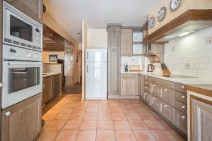 卡尼略Xalet Kotki HUT1-005472的一间大厨房,配有白色家电和棕色橱柜