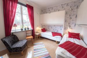 HasselöHasselö Hostel的一间卧室设有两张床、一把椅子和一个窗户。