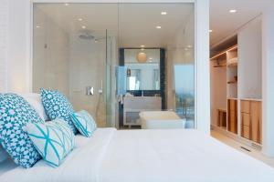 普拉迪斯亚罗斯麦柯尼亚安大使罗莱夏朵酒店的卧室配有白色床和蓝色及白色枕头