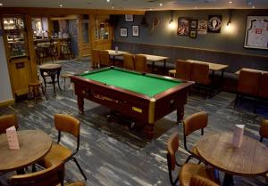 奥尔弗里顿The Horse & Jockey的酒吧设有一张台球桌,配有桌椅