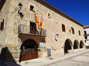 El CastellarHotel Rural Curia的一座石头建筑,阳台上悬挂着两面旗帜