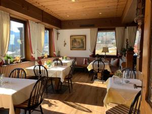 巴特莱辛哈尔Hotel Restaurant Neu Meran的餐厅设有白色的桌椅和窗户。