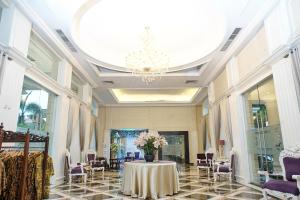梭罗阿迪旺萨酒店的配有桌椅和吊灯的客房