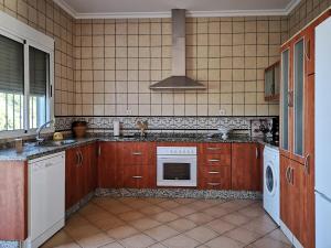 厄尔-汝姆披多Casa Rural Cerca de la Playa El Rompido的厨房配有木制橱柜和白色的电器
