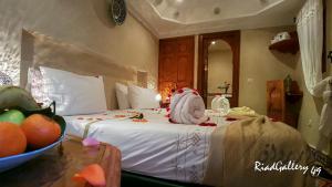 马拉喀什里亚德画廊49号庭院旅馆的一间卧室,配有一张床上的床铺,桌上放着一碗水果