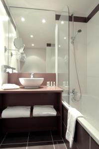 瓦龙Hôtel Le Palladior Voiron的一间带水槽和淋浴的浴室