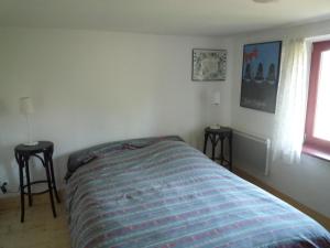 EschbourgLes Rosiers的一间卧室配有一张带两张桌子和一扇窗户的床。