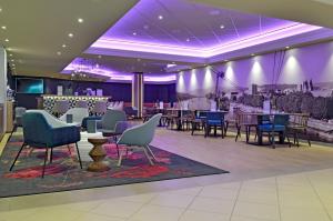 科布伦茨科布伦茨美居酒店的一间配备有桌椅和紫色照明的用餐室