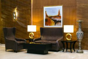 巴格达Babylon Rotana Hotel的客厅配有两把椅子和一个花瓶