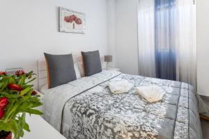 洛斯克里斯蒂亚诺斯Almar Apartamento en Los Cristianos con AC的一间卧室配有一张床和一张植物桌子