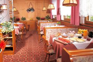 纳莱斯Pension Stamserhof的一间餐厅,配有两张桌子,上面有食物