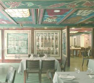 坎弗兰克埃斯塔西翁圣克里斯蒂娜珀蒂Spa酒店的一间带桌椅的用餐室和一个带彩绘天花板的天花板