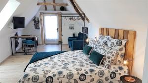 勒比格le clos des etoiles B&B的一间卧室配有一张大床和一张蓝色椅子
