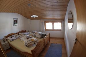 迪森蒂斯Ferienwohnung Rigoleth的配有木天花板的客房内的两张床