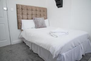 贝肯翰姆TLK Apartments & Hotel - Beckenham的卧室配有一张大白色的床和大床头板