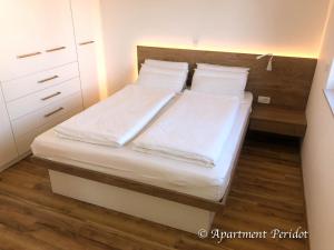 克拉尼斯卡戈拉VILA Mojca - APARTMENT PERIDOT - Center的一间卧室配有两张带白色床单和枕头的床。